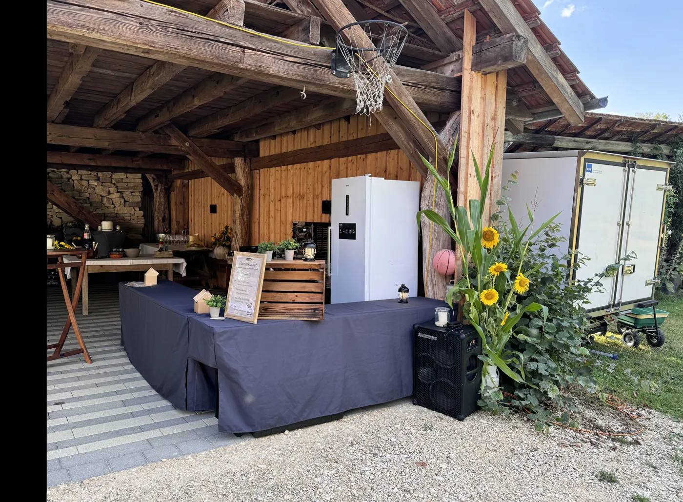 Aufgebaute Eventausstattung der Flammkuchen-Zentrale bei einer Feier im Hegau: Theke mit Husse, Kühltechnik und Dekoration